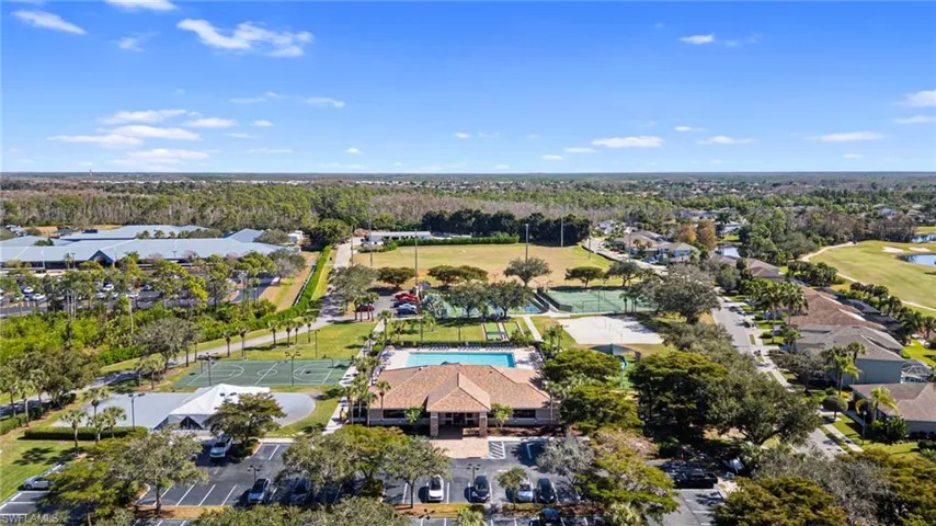 Aerial view of residential area featuring a nearby body of water and a golf course