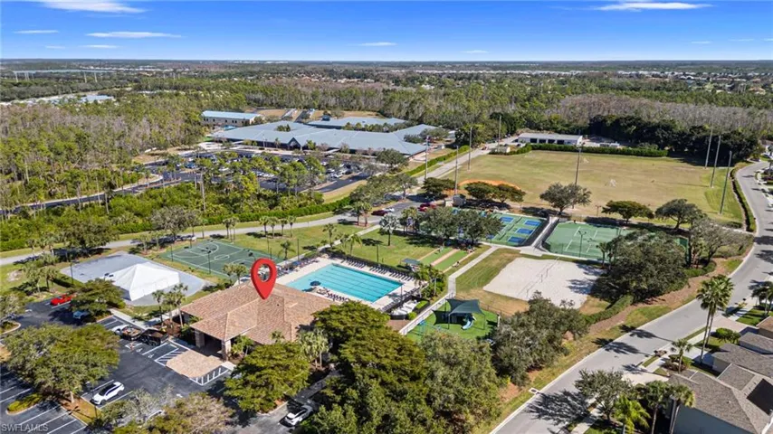 Aerial view of property's location featuring a heavily wooded area and a pool