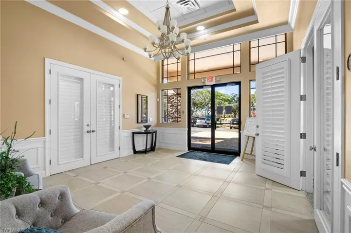 Common area with ornamental molding, wainscoting, a decorative wall, recessed lighting, and a towering ceiling