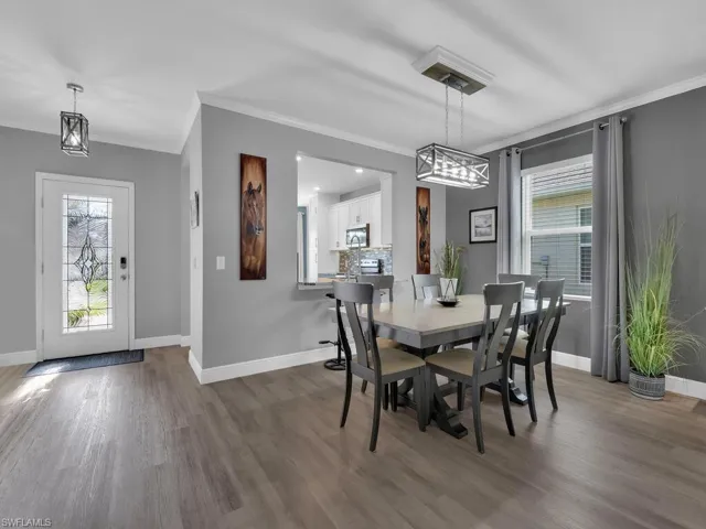 Dining room with crown molding, wood finished floors, and a chandelier