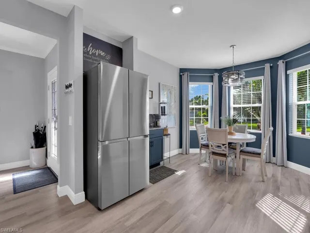 Kitchen featuring freestanding refrigerator, decorative light fixtures, light wood finished floors, a chandelier, and recessed lighting