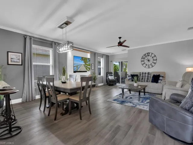 Dining area featuring crown molding, light wood-style floors, and a ceiling fan