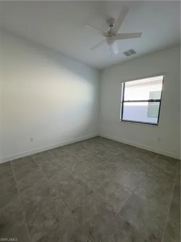 Spare room featuring baseboards and ceiling fan