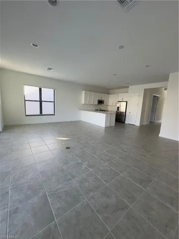 Unfurnished living room with baseboards and dark tile patterned flooring