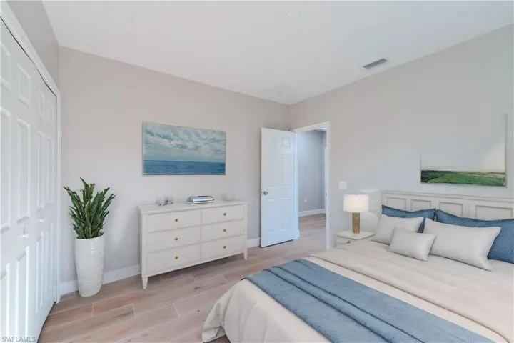 Bedroom featuring baseboards, visible vents, and wood tiled floor
