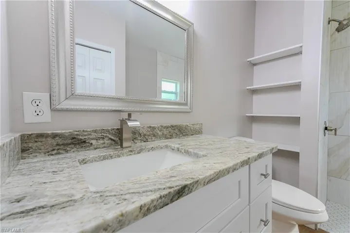 Full bathroom with toilet, vanity, and a shower stall