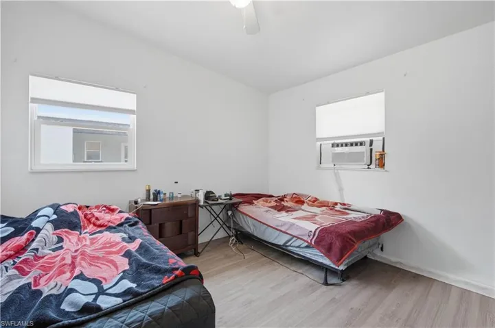 Room featuring light wood-finish flooring, white walls, and a ceiling fan