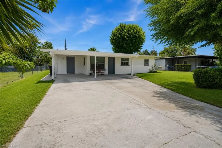 Single-story residence featuring a white exterior with a covered front entry and a concrete driveway