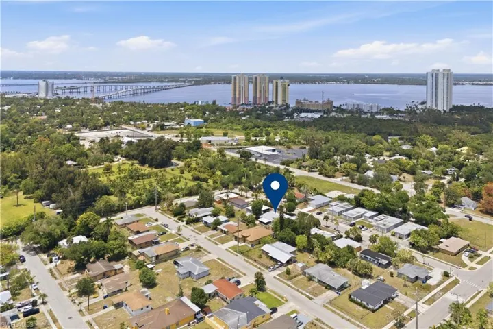 Aerial perspective of a residential neighborhood with a prominent water body and distant structures