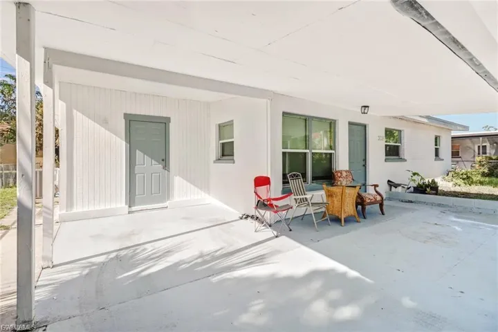 Covered carport space with a light gray painted concrete floor