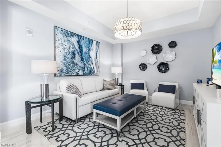 Den featuring a raised ceiling