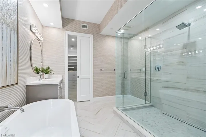 Bathroom featuring separate shower and tub and vanity