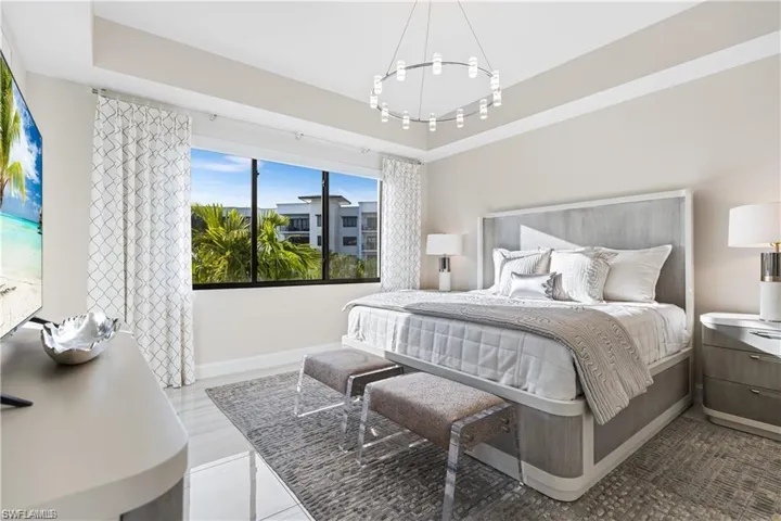 Bedroom featuring a raised ceiling and an inviting chandelier