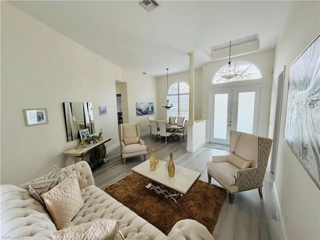 Living room featuring wood finished floors, french doors, and a chandelier