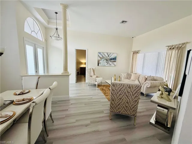 Living room featuring ornate columns and wood finished floors