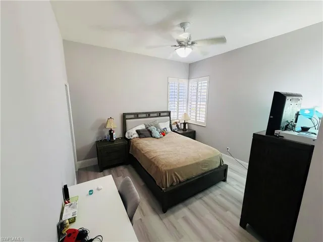 Bedroom with light wood finished floors and a ceiling fan