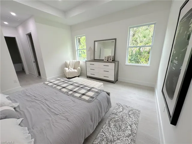 Bedroom featuring multiple windows and light wood-type flooring