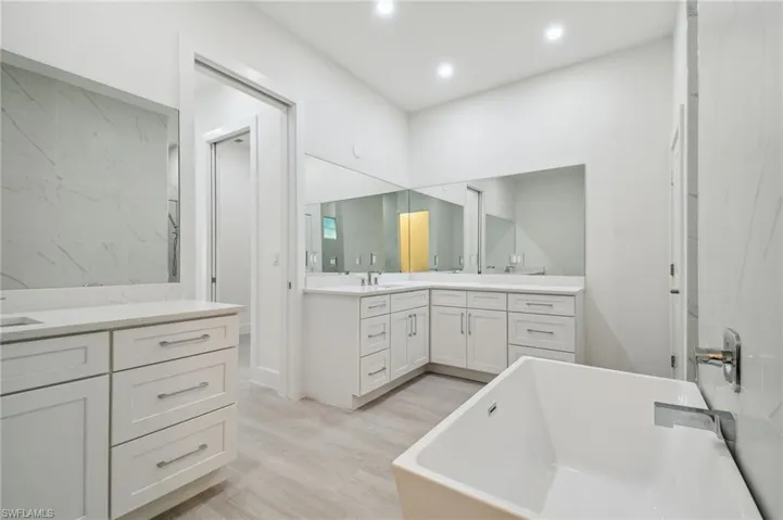 Bathroom featuring vanity, hardwood / wood-style floors, and a washtub
