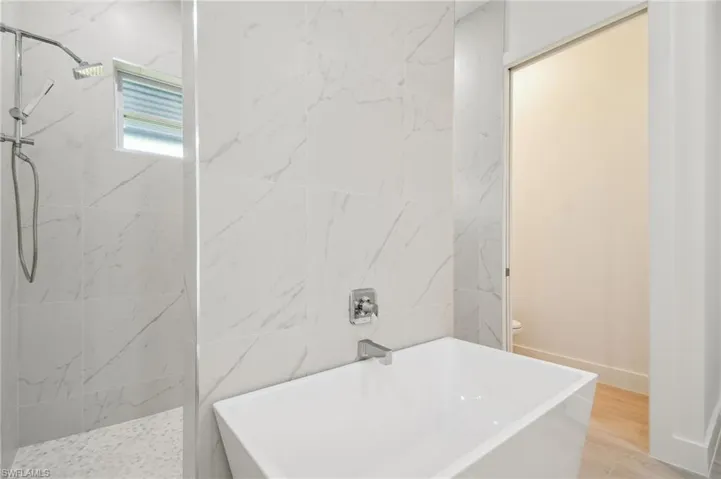Bathroom with separate shower and tub, wood-type flooring, and toilet