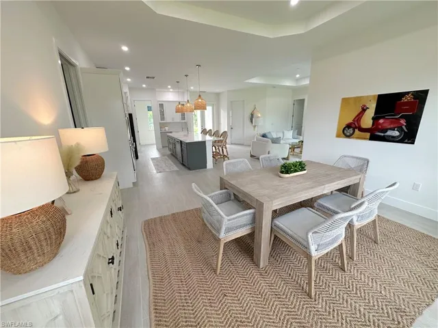 Dining area featuring a tray ceiling and light wood-type flooring