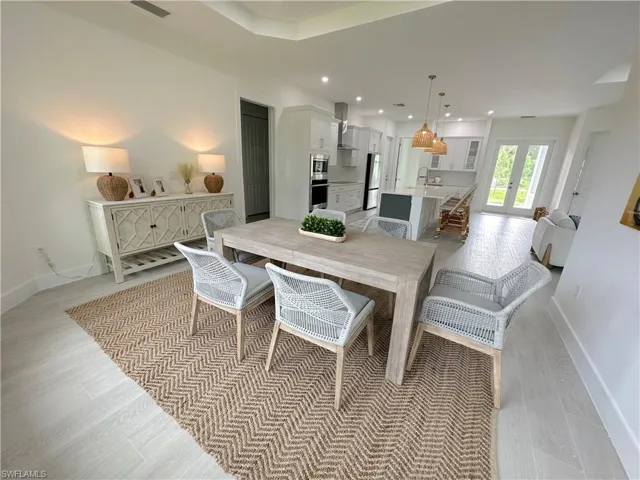 Dining space with french doors, sink, and light wood-type flooring