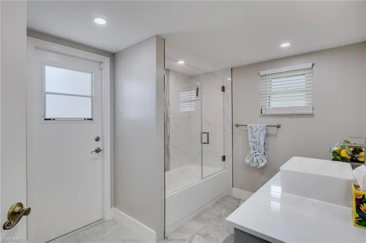 Full bath with vanity, combined bath / shower with glass door, and recessed lighting