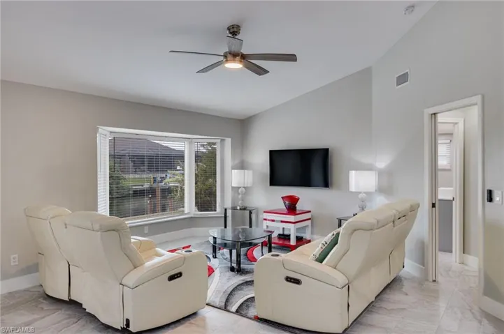 Living room with vaulted ceiling and a ceiling fan