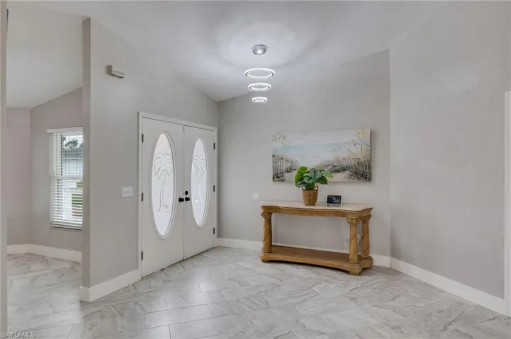 Foyer with lofted ceiling and baseboards