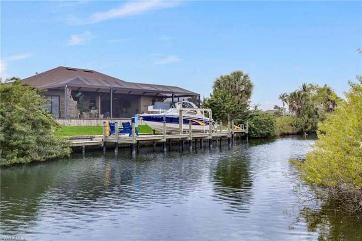 Dock featuring boat lift, a water view, a sunroom, and a lanai