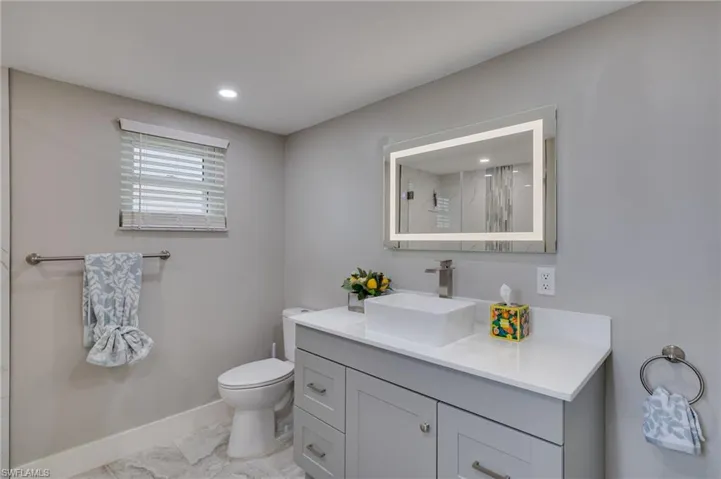 Full bath with vanity, a marble finish shower, recessed lighting, and light marble finish flooring