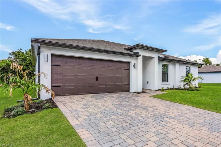 View of front of property with a garage and a front yard