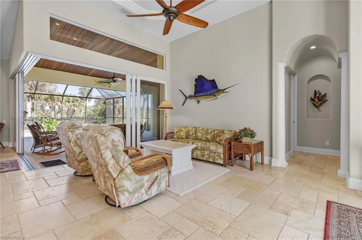 Living room with 90-degree sliders opening to in-ground pool