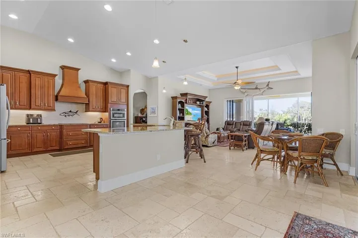 Kitchen featuring large island with granite and travertine tile floors