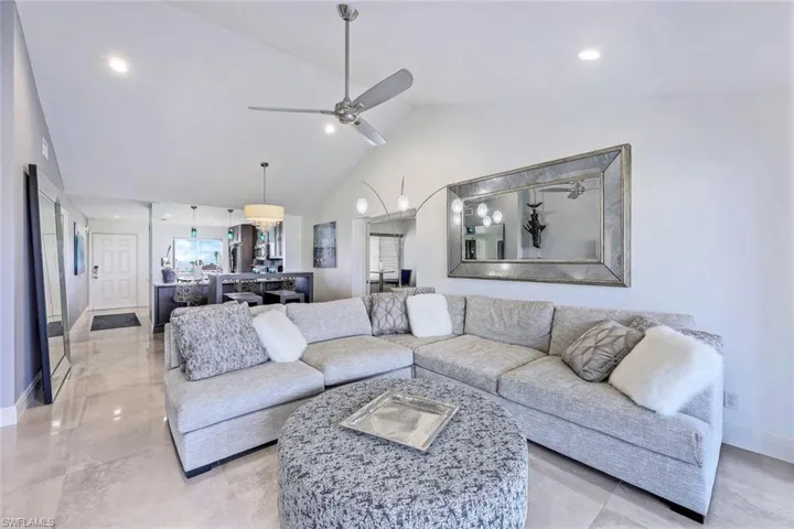 Living room featuring ceiling fan and high vaulted ceiling