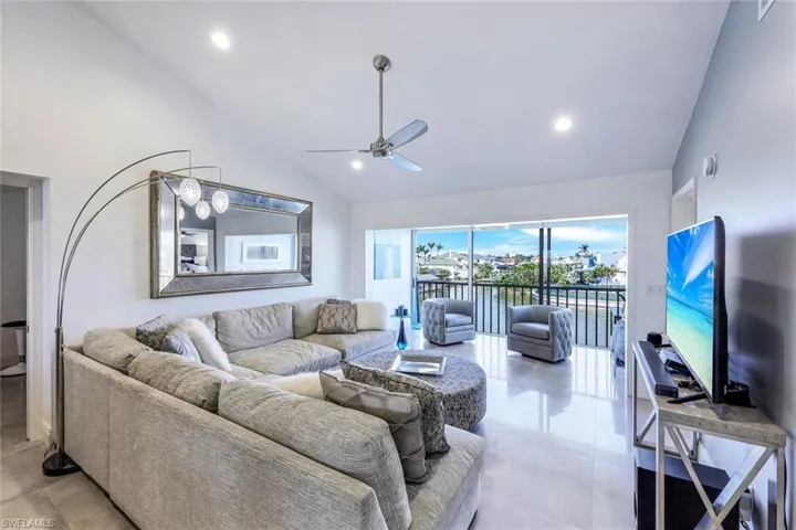 Living room featuring ceiling fan and high vaulted ceiling