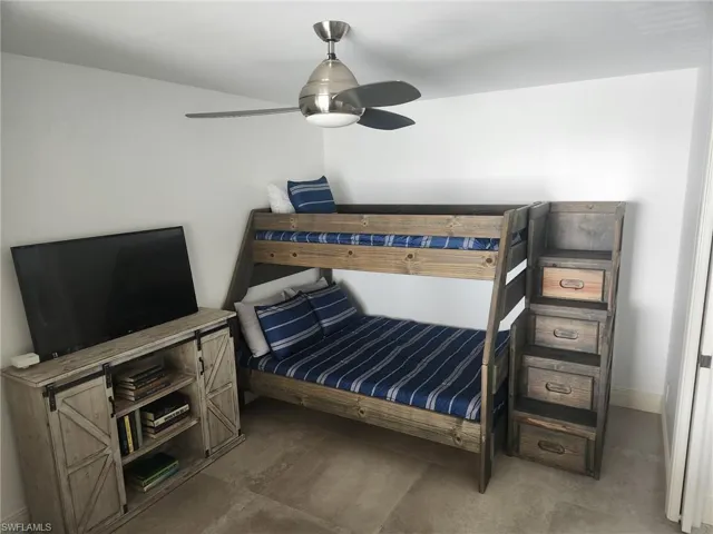 Bedroom with concrete flooring, ceiling fan, and baseboards