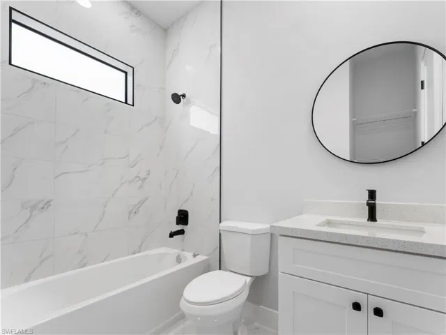Full bathroom featuring vanity, toilet, and tiled shower / bath