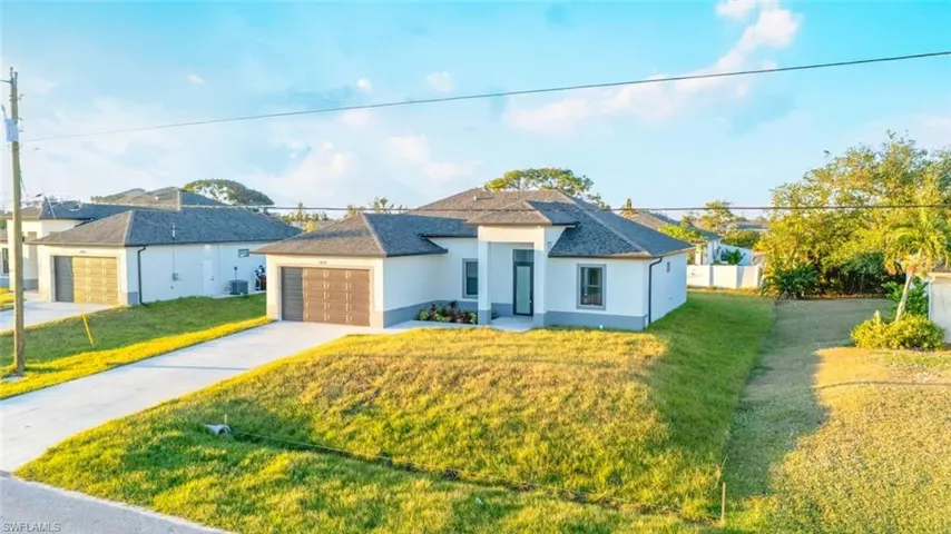View of front of house with cooling unit, a front lawn, and a garage