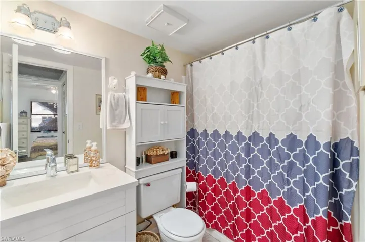 Guest bathroom with updated vanity with quartz countertop and newer lighting fixture.