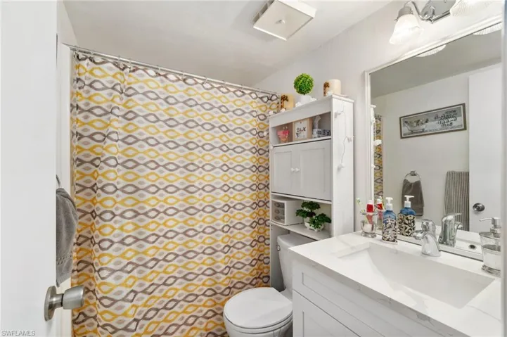 Primary bathroom with updated vanity with quartz countertop and newer lighting fixture.