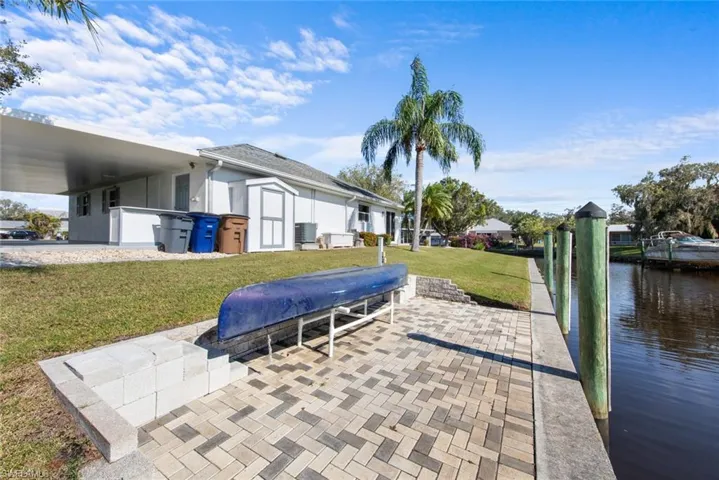 View of patio with a boat dock, a water view, and central AC