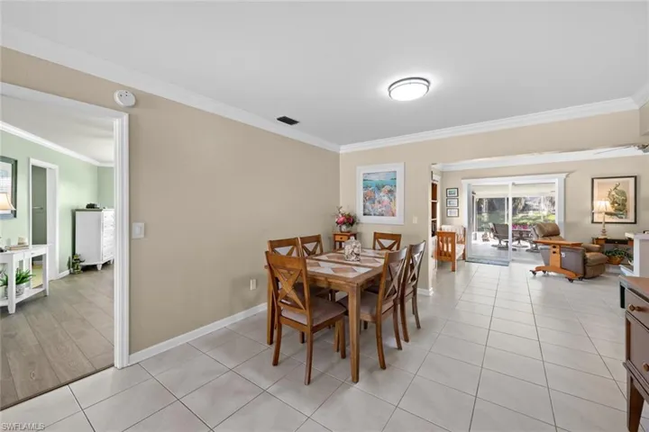 Tiled dining space featuring crown molding