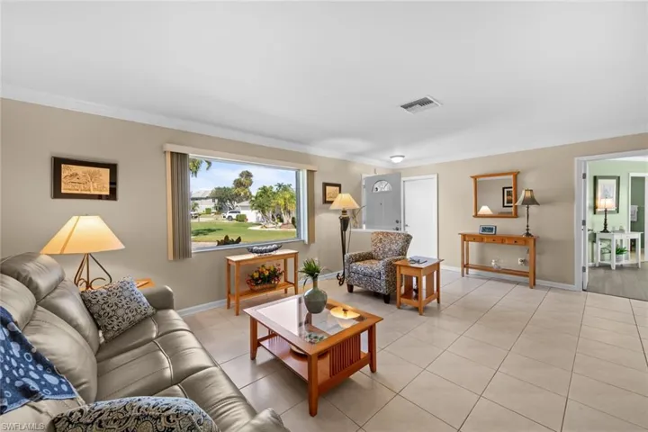 Living room with light tile patterned floors and ornamental molding