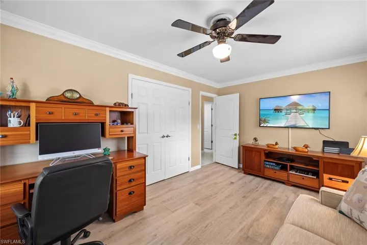 Office area featuring ceiling fan, light hardwood / wood-style floors, and crown molding