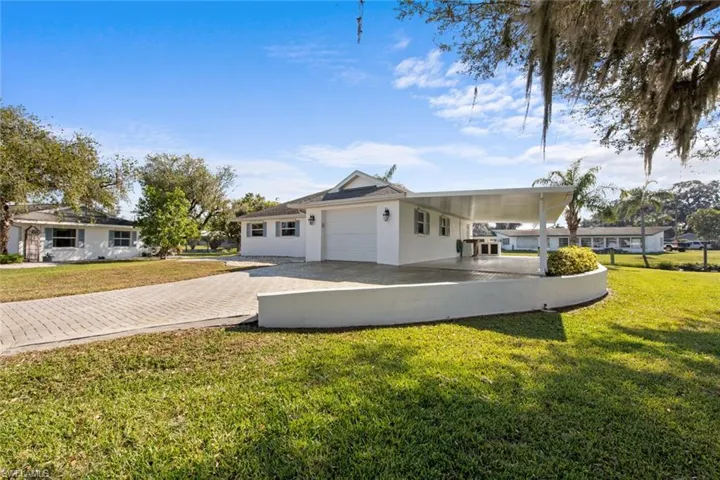 View of front facade with a front yard and a carport