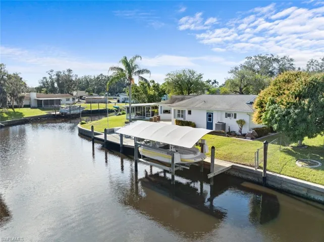 Dock area with a water view and a lawn