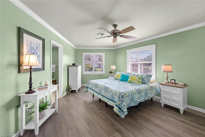 Bedroom featuring ceiling fan, hardwood / wood-style flooring, and ornamental molding