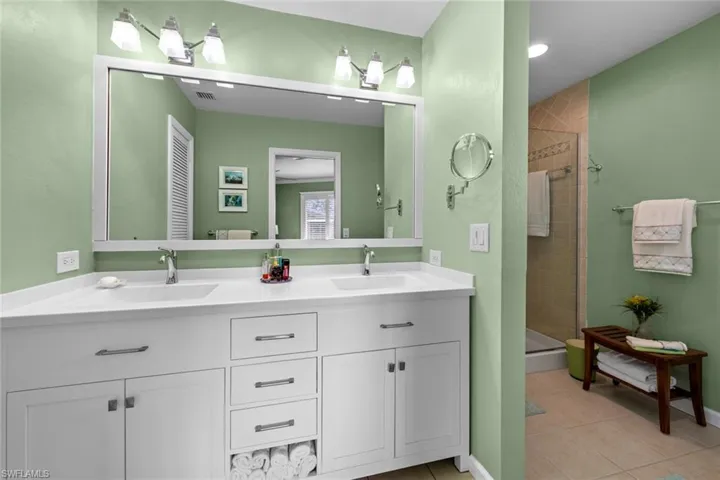 Bathroom featuring tile patterned floors, vanity, and an enclosed shower