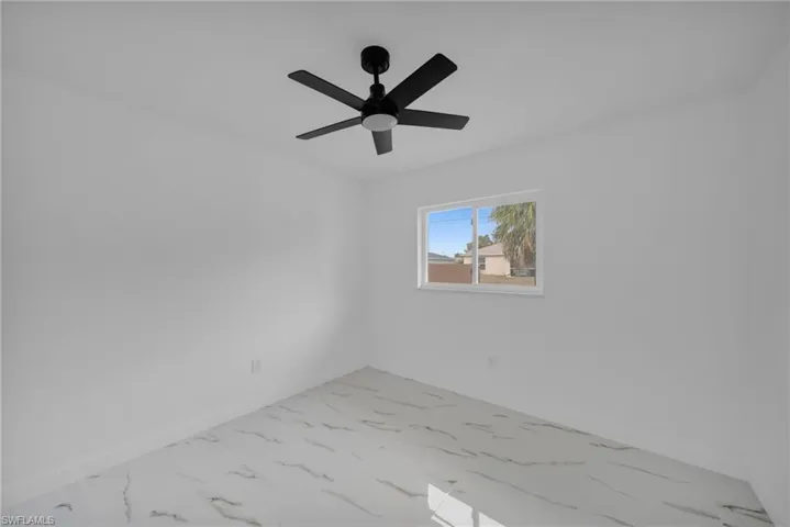 Empty room featuring marble finish flooring and ceiling fan
