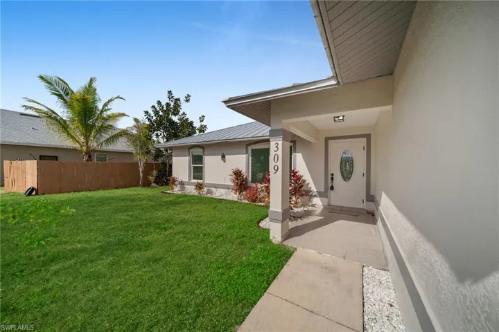 Entrance to property with stucco siding and a metal roof